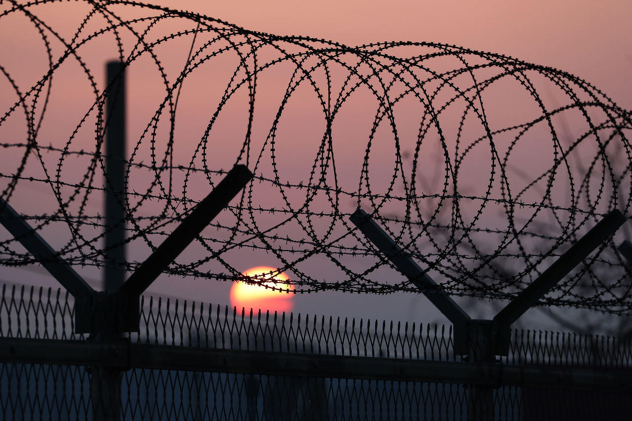 The sun rises behind a barbed-wire fence at a military checkpoint on the Unification Bridge, linked to North Korea, near the Demilitarized Zone in Paju, Gyeonggi Province,  Jan. 9, 2018. (Bloomberg via Getty Images)