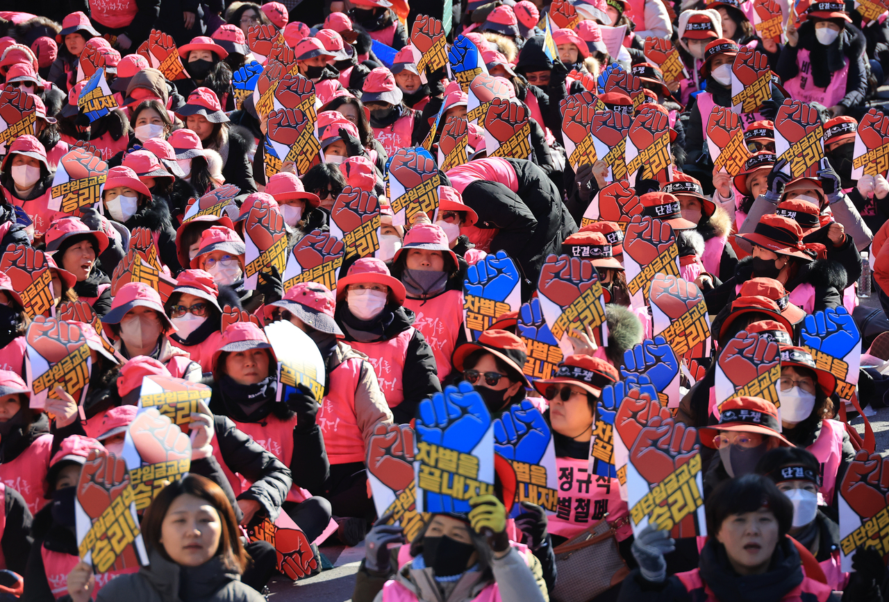 School workers joining a strike rally held by the National School Irregular Workers’ Union Coalition chant slogans in front of the National Assembly in Seoul’s Yeouido district on Thursday. (Yonhap)