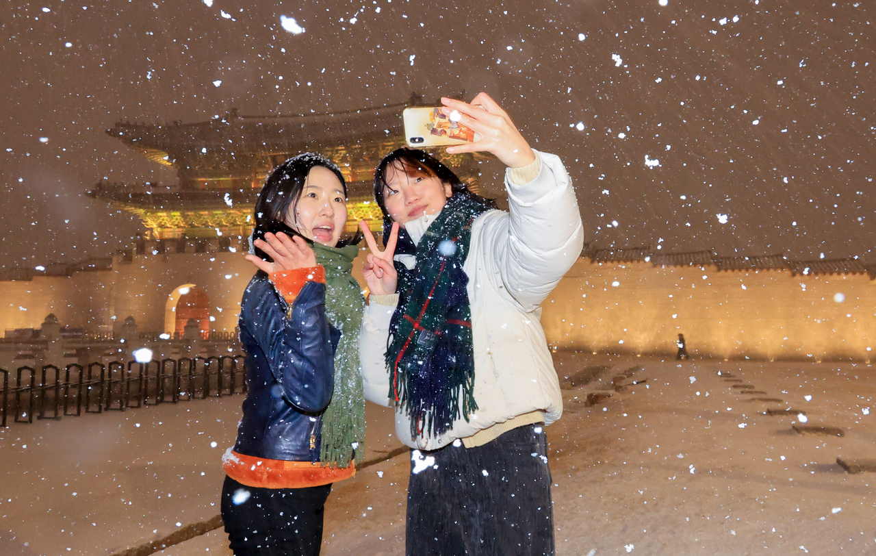 Citizens celebrate the first snowfall at Gwanghwamun Square in central Seoul on Thursday. (Yonhap)
